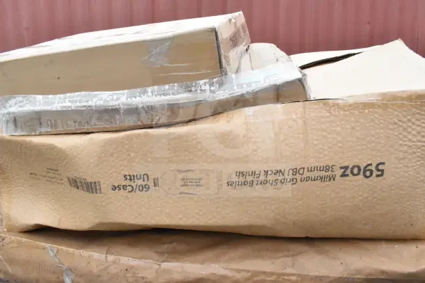 Cardboard boxes, slightly damaged, labeled for grip bottles, containing a pan rack and bottles, part of scratch and dent auction.