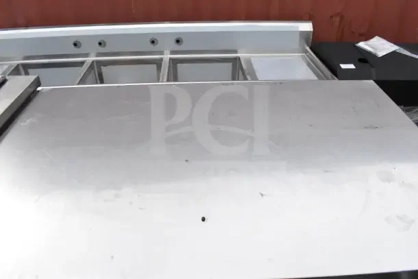 Stainless steel table with under shelf, scratches on surface, ideal for kitchen use, sturdy construction. Tags or labels not visible.