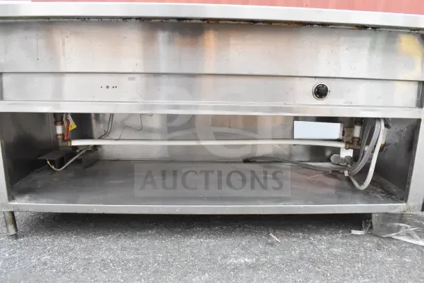 Industrial stainless steel steam table with under shelf, visible wiring, and control knob on the front, in used condition.