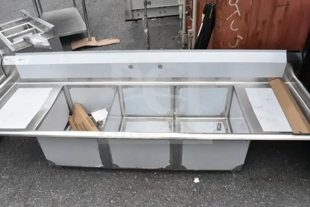 Brand new Steelton 522CS31620LR commercial 3 bay sink with dual drain boards, showing minor scratches and dents.