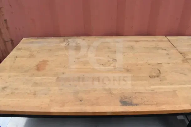 Wood pattern countertop with two-tier under shelf, showing signs of wear. Ideal for kitchen or workshop use.