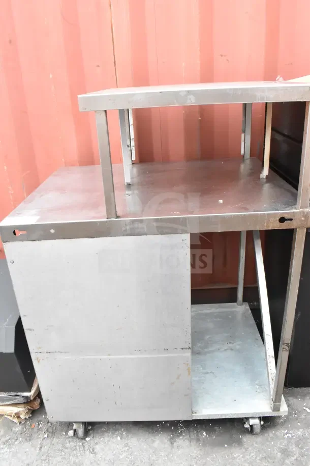 Stainless steel cart with over shelf, commercial casters, used condition, visible shelf supports, suitable for heavy-duty use.