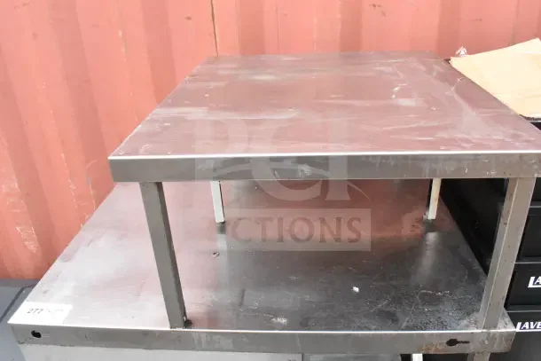 Stainless steel cart with over shelf, commercial casters, visible surface wear, auction tag "277," sturdy design.