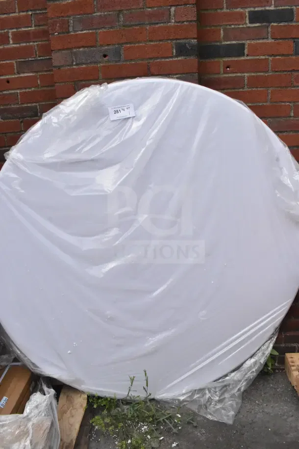 Brand new white round folding table, wrapped in plastic. Visible condition: scratch and dent. Tag marked "281".