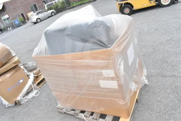Large pallet with assorted items covered in clear plastic wrap, labeled "10 BRAND NEW SCRATCH AND DENT!"
