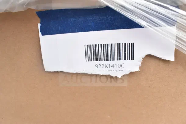 Torn label on cardboard showing barcode and code 922K1410C, indicating part of a scratch and dent auction lot.