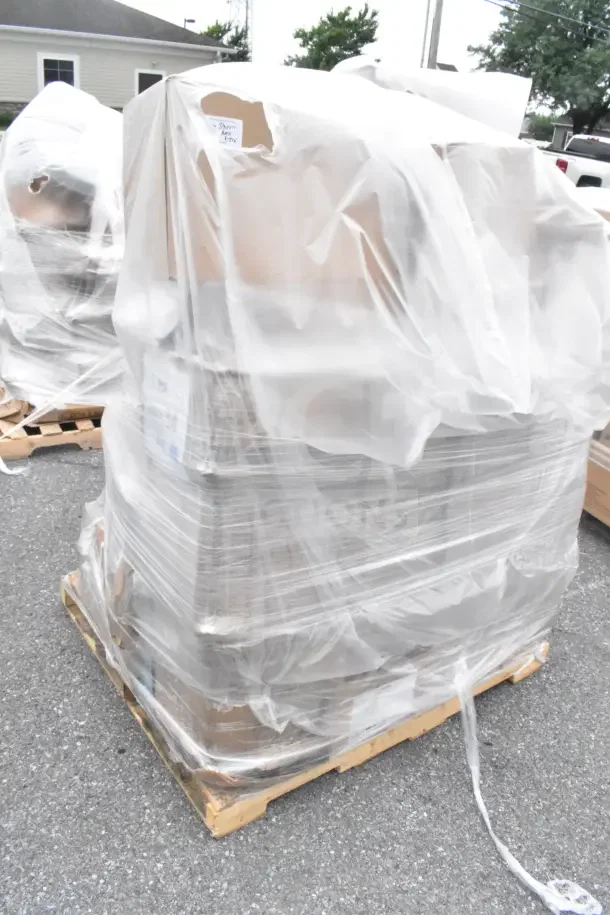 Brand new scratch and dent lot including glass rack, plates, and condiment caddy, wrapped in plastic on a pallet.