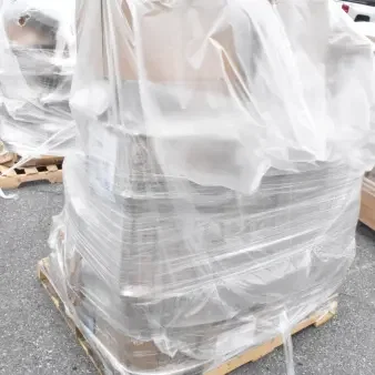 Brand new scratch and dent lot including glass rack, plates, and condiment caddy, wrapped in plastic on a pallet.