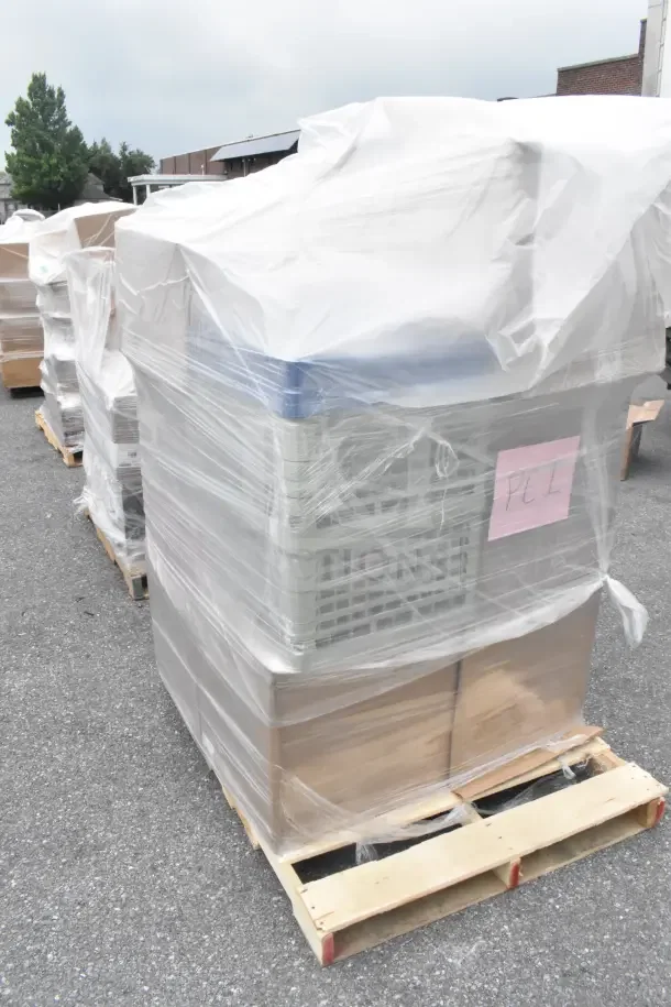 Plastic-wrapped pallet of 34 scratch and dent items, including glass caddies, labeled "PE1," ready for auction.