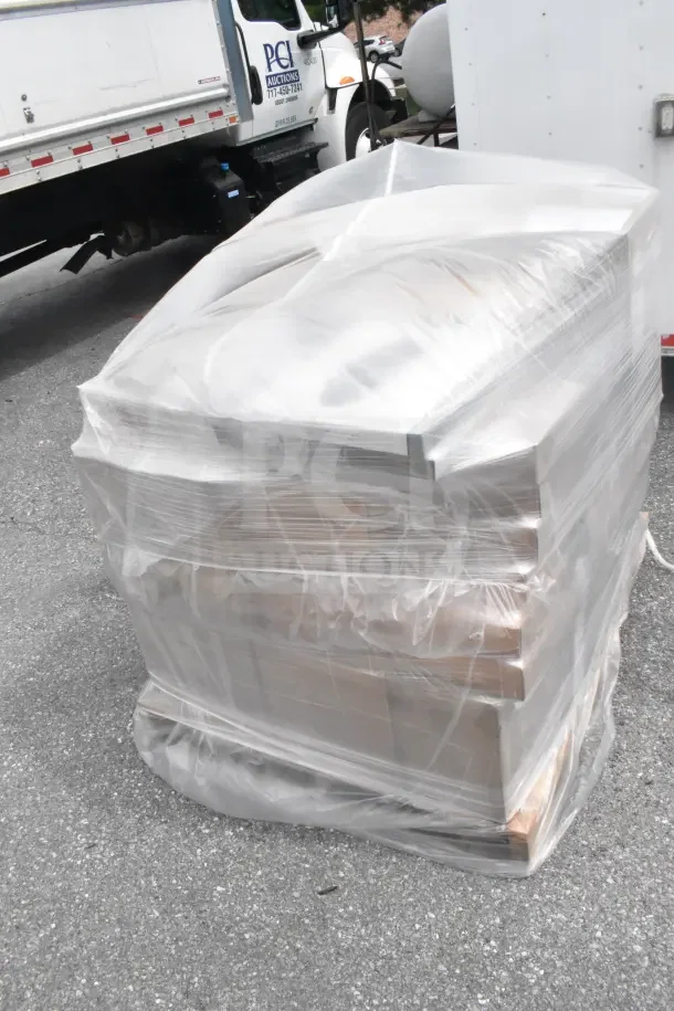 Plastic-wrapped pallet containing 26 brand new scratch and dent items, including trays, bowls, and cutlery, awaiting auction.