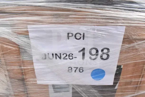 Plastic-wrapped pallet with auction label "PCI JUN26-198" containing 13 scratch and dent items, including dough sheeter and trash cans.