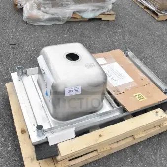 Brand new counter with sink bay, scratch and dent condition, stainless steel, stacked on a pallet with packaging labels visible.