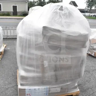 Shrink-wrapped pallet of 21 brand new scratch and dent items, including grinder plates and wine glasses, on asphalt surface.