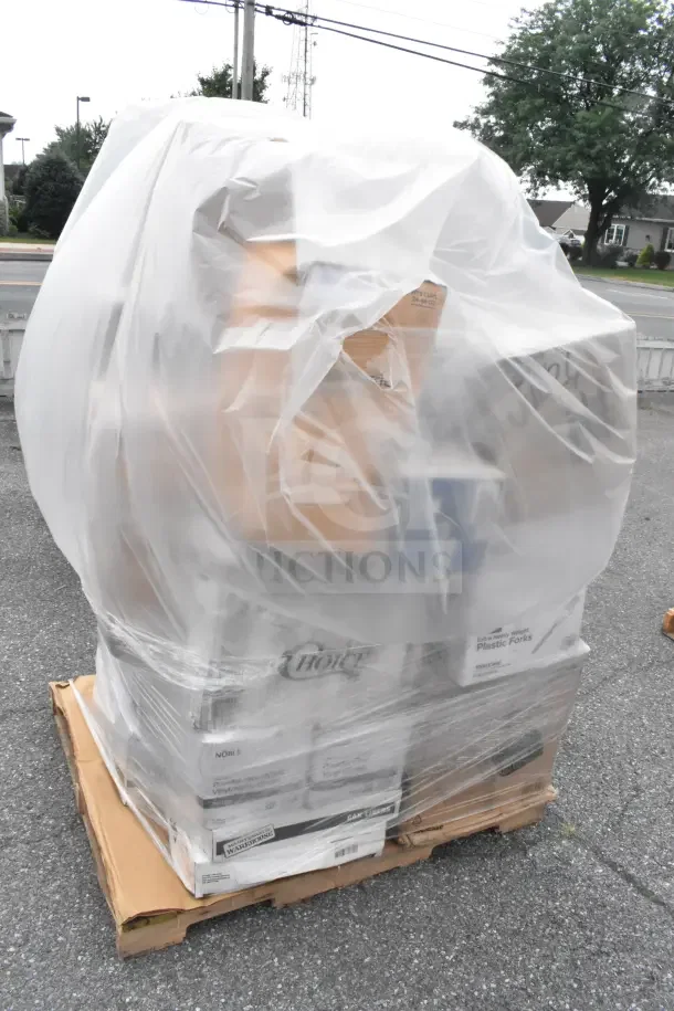 A pallet wrapped in plastic containing 29 scratch and dent items, including containers, forks, napkins, and trash bags.