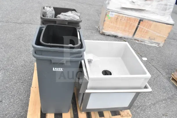 Three brand new Lavex items with scratch and dent condition: two gray trash cans and a white utility sink on a pallet.