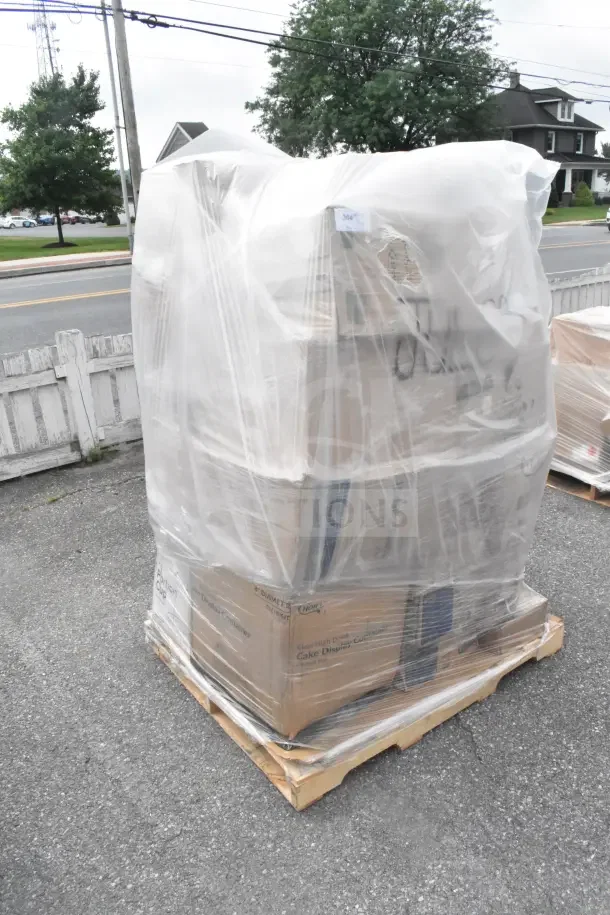 Pallet of brand new scratch and dent items wrapped in plastic, includes wax paper, portion cups, lids, and paper towels.