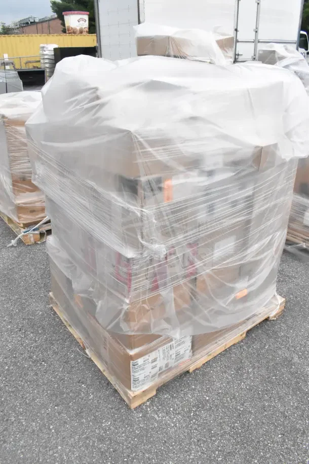Pallet with 45 new scratch and dent items wrapped in clear plastic, including glasses, spoons, and food mill.