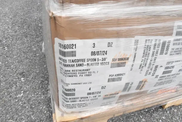 Cardboard box labeled with "Antico Tea/Coffee Spoon" and "Antico Dessert Spoon," wrapped in plastic for auction.