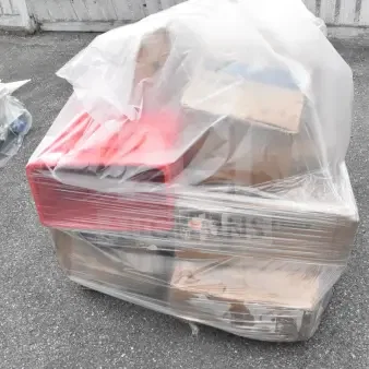 Shrink-wrapped pallet with 11 brand new but scratch and dent items, including a red work table, plates, and mop bucket.