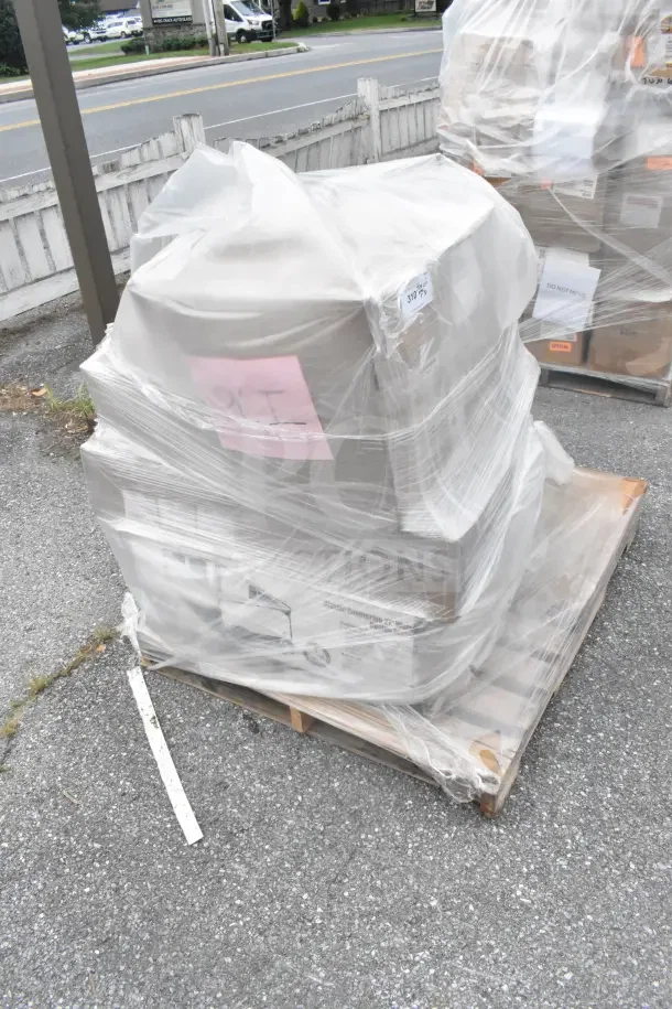 7 brand new scratch and dent items on a pallet, wrapped in plastic, including a stock pot with visible pink and white labels.