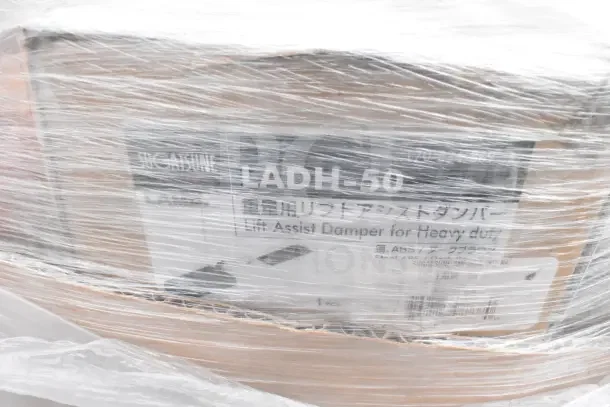 7 new scratch-and-dent items wrapped in plastic, featuring a stock pot. Box label reads "Lift Assist Damper for Heavy Duty."