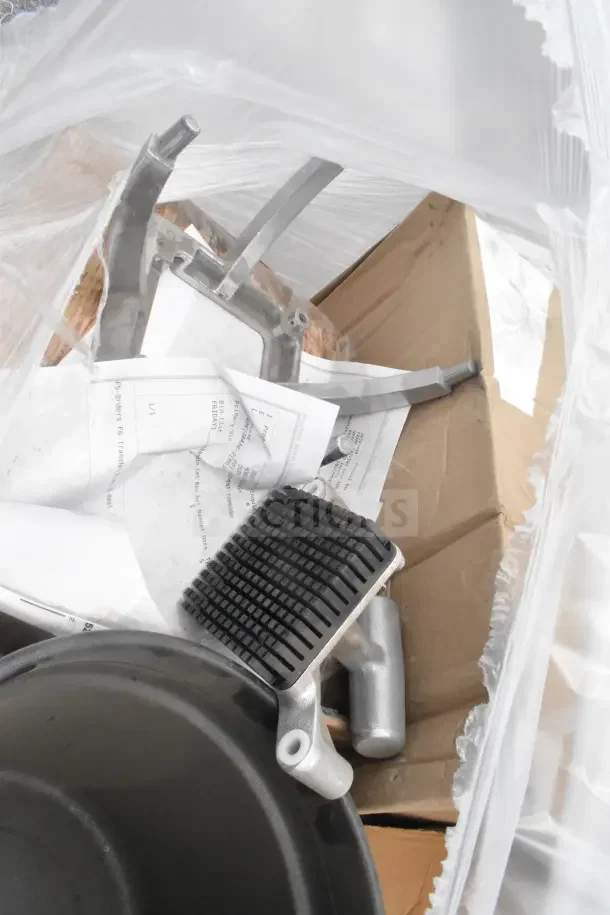Seven brand new scratch and dent items, including a stock pot, visible in packaging with metal parts and documents.