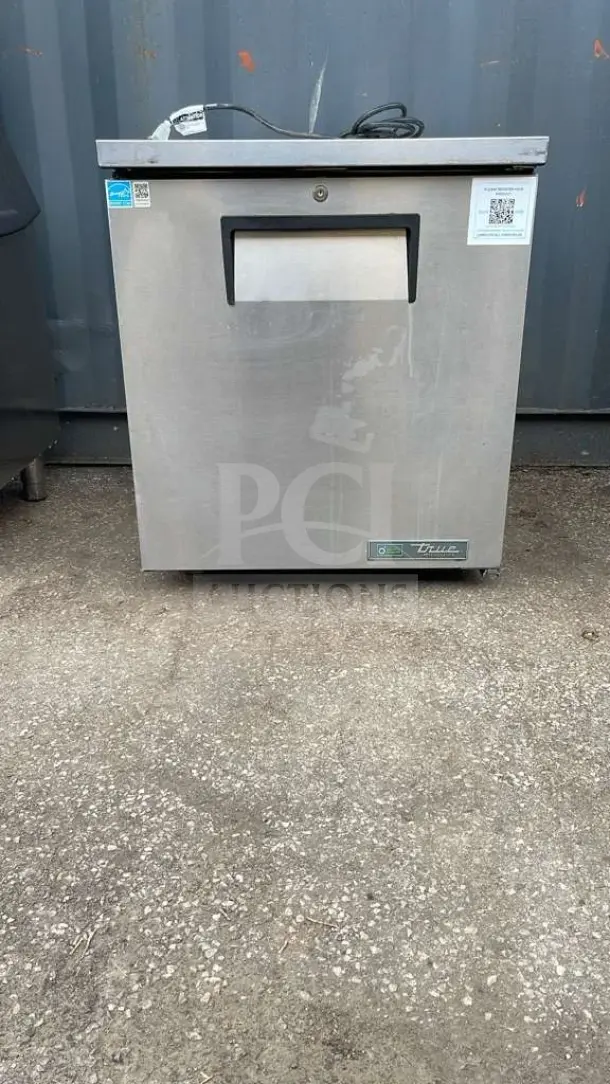 True TUC-27-HC undercounter refrigerator, stainless steel, minor surface wear, visible logos and QR code on front.