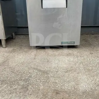 TRUE TUC-27-HC undercounter refrigerator, stainless steel, visible wear, model and energy labels on front.
