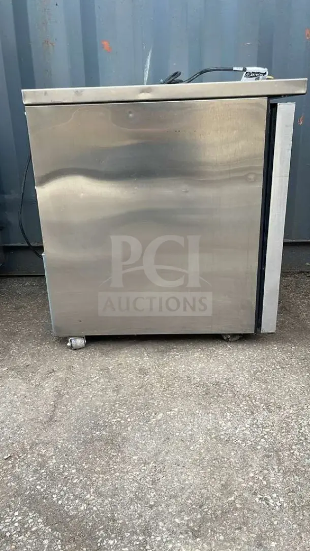 TRUE TUC-27-HC undercounter refrigerator; stainless steel exterior; visible wear; model label on top left corner.