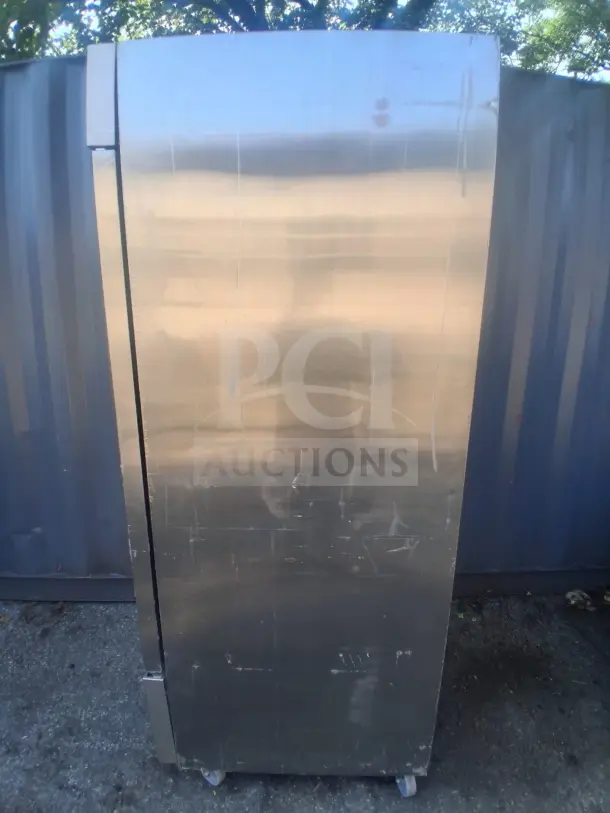 Dukers D28R commercial reach-in refrigerator, stainless steel exterior, scratch marks visible, rolling casters.