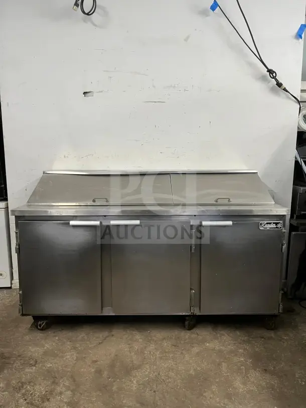 LEADER NSFM72 72" 3-door refrigerated prep table with mega top for sandwiches and salads. Model: NSFM72, in good condition.