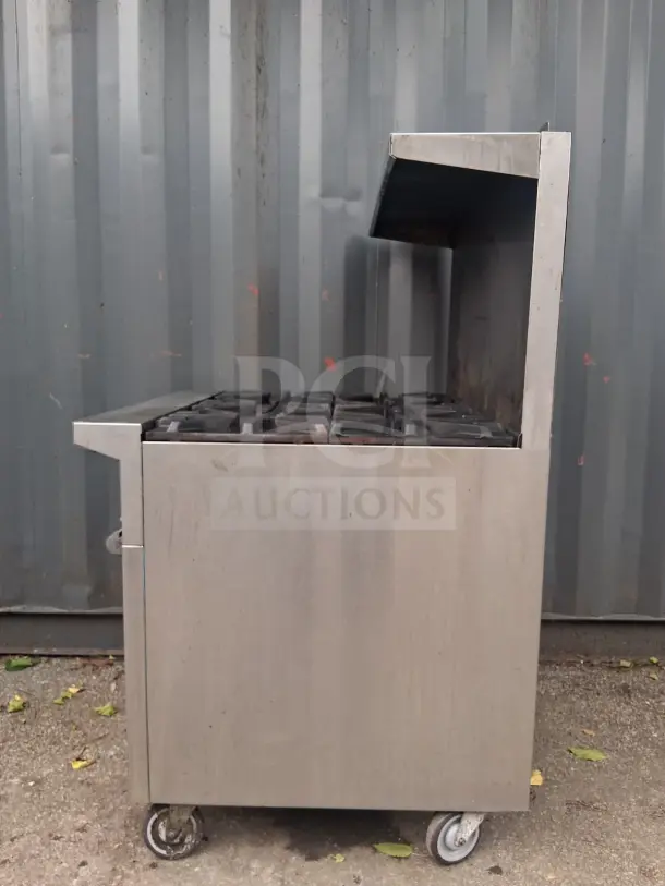 U.S. Range 36" natural gas range with 6 burners and standard oven, stainless steel exterior, on wheels, used condition.