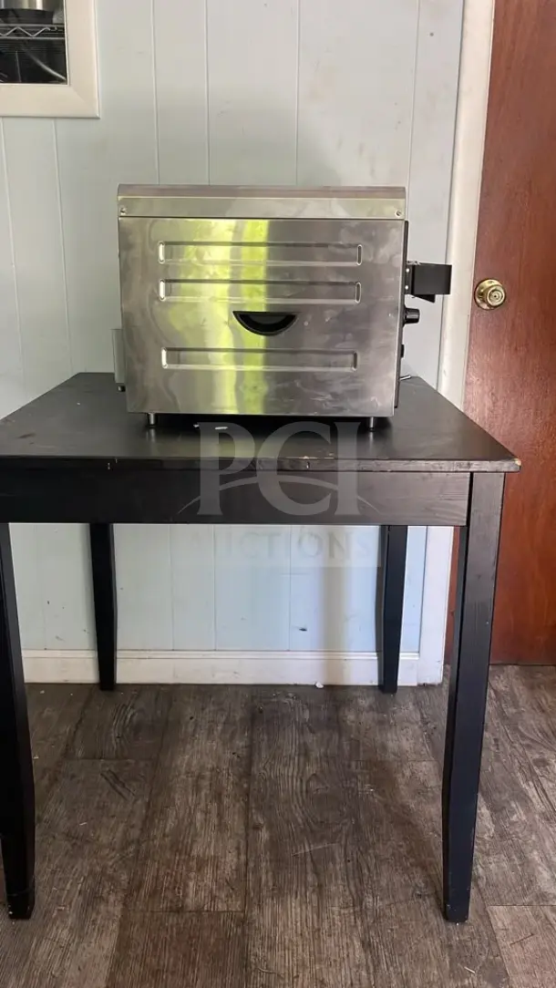 Waring CTS1000 Commercial Conveyor Toaster on black table, stainless steel exterior, 120V, good condition.