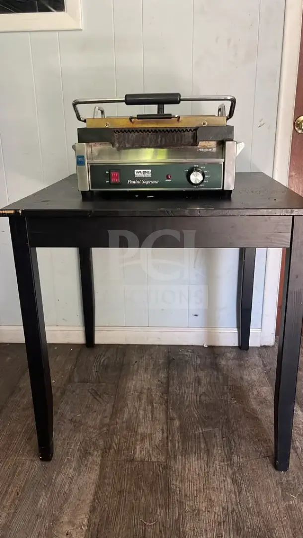 Waring WPG250TB Panini Supremo grill, grooved plates, timer, 14 1/2" x 11" surface, 208V, 2808W, on a table, used condition.