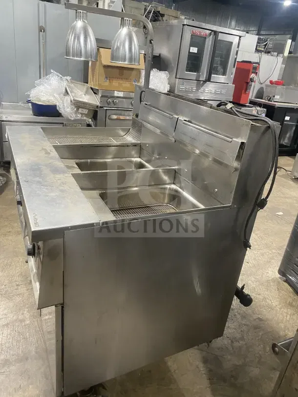 Keating stainless steel dual instant recovery fryer, model 14TSSI, natural gas-powered, with backsplash, on casters.