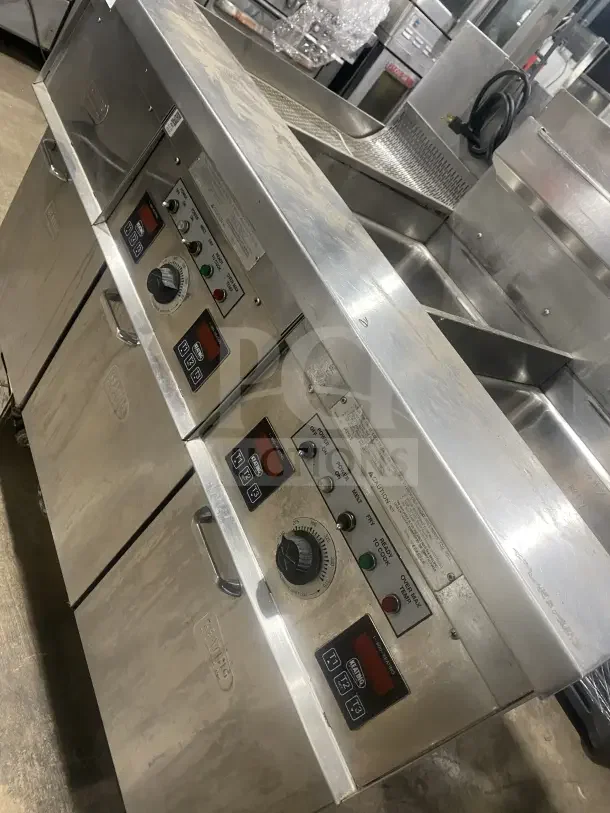 Keating stainless steel natural gas dual fryer, model 14TSSI, on casters, with heating element and backsplash. SN: FE46064.