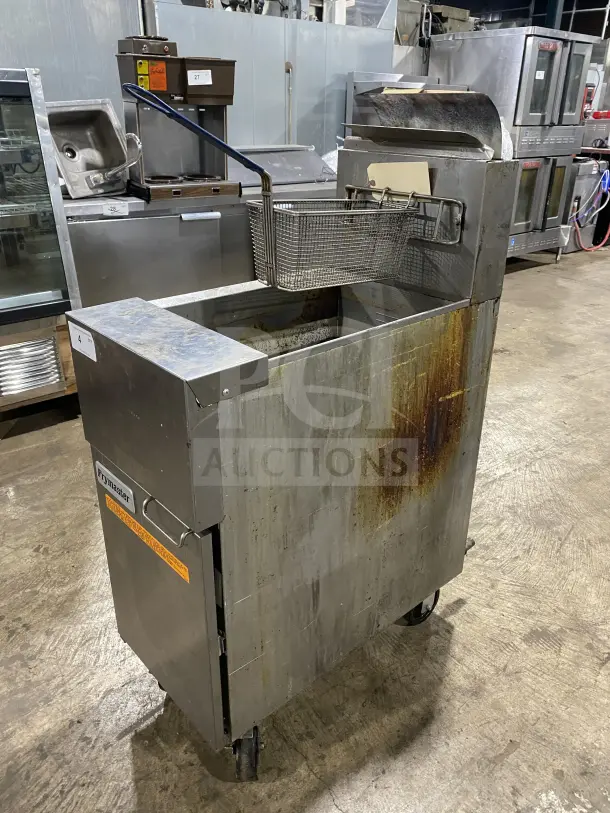 Frymaster commercial stainless steel gas deep fat fryer with backsplash, basket hanger, fry basket, and casters. Some wear visible.
