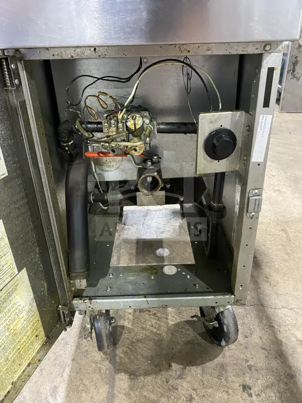 Frymaster commercial stainless steel gas fryer, with back splash, basket hanger, fry basket, on casters. Visible internal components.