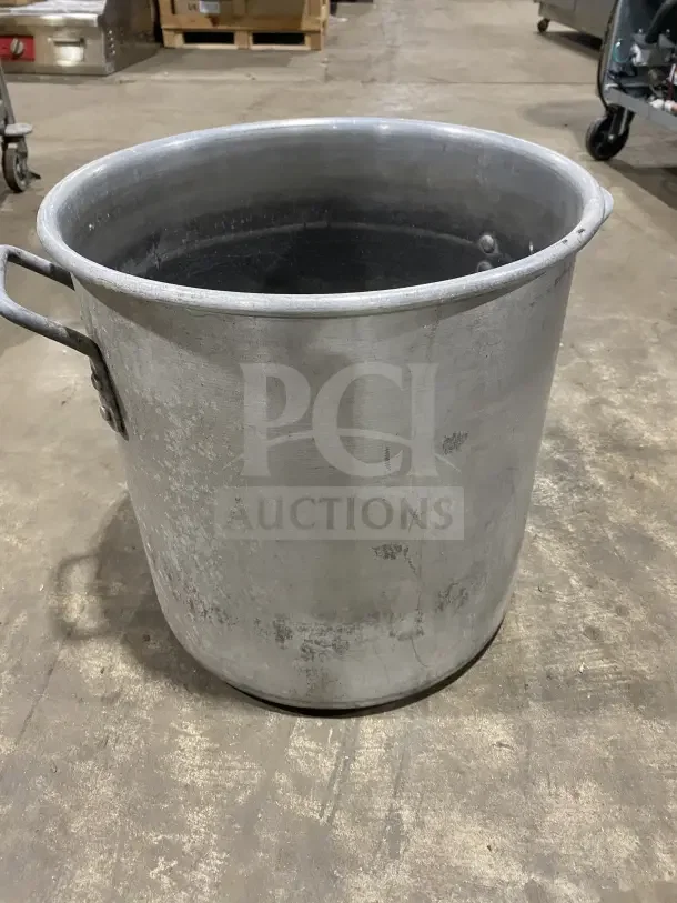Commercial heavy-duty aluminum stock pot with handles, used condition, suitable for mixing or cooking, visible surface wear.