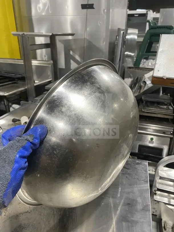Commercial stainless steel mixing bowl in used condition. Features durable construction, visible wear marks. Multipurpose kitchen tool.