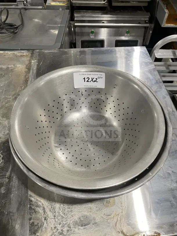 Commercial stainless steel colanders, set of two. Durable, used. Label indicates doubling of bid quantity.