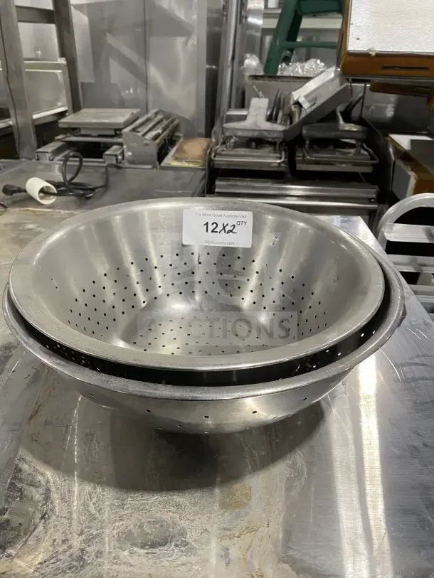 Commercial stainless steel colanders, set of two, new condition, with perforated design for efficient draining.
