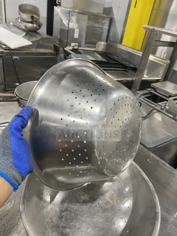 Stainless steel colanders in used condition, features perforated design, visible wear, perfect for commercial kitchen use.