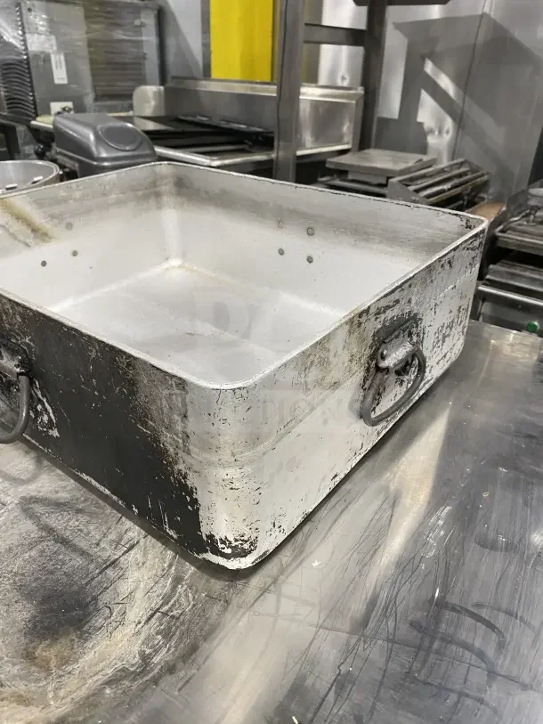 Commercial heavy-duty aluminum roast/bake pan with drop handles, used condition, signs of wear, ideal for professional kitchens.