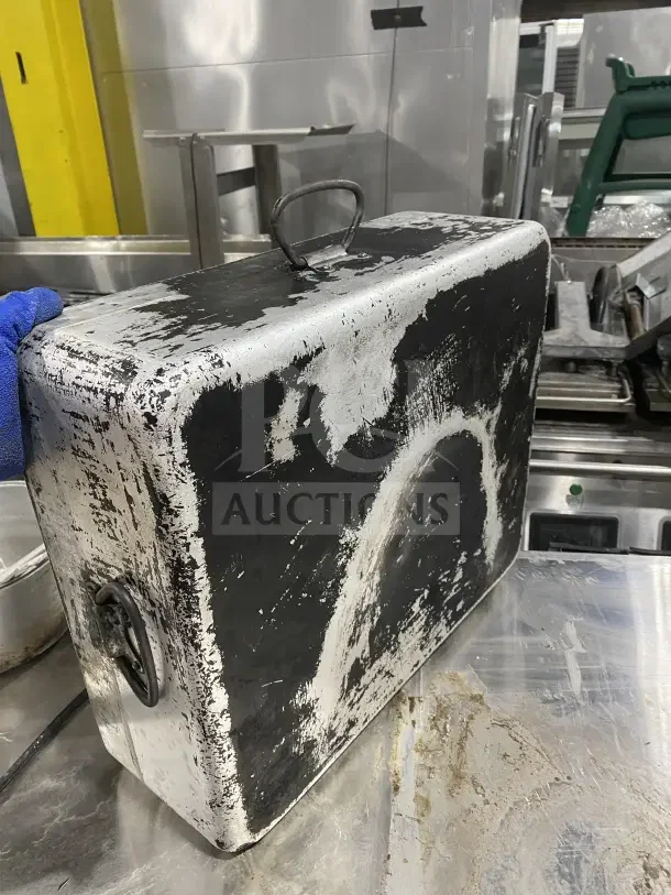 Commercial heavy-duty aluminum roast/bake pan with drop handles, worn condition, showing significant use.