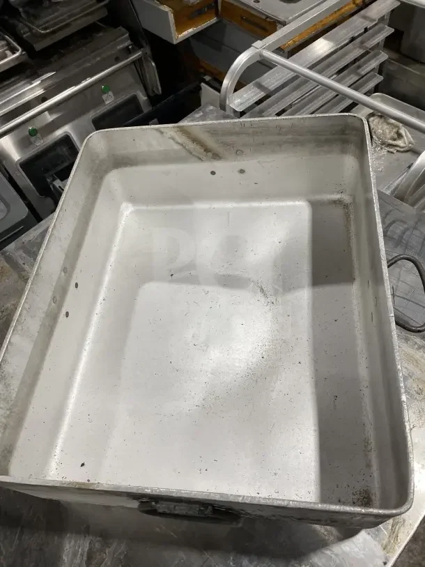 Heavy-duty aluminum roast/bake pan with drop handles, used condition, visible scuffs and marks, ideal for commercial use.