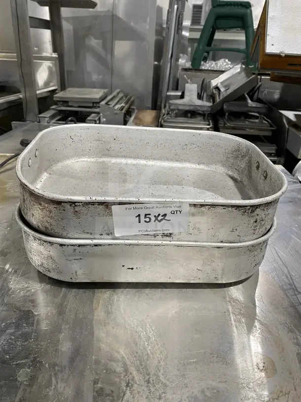 Commercial aluminum roasting/baking pans with handles, auction label "15X2", used condition, visible wear.