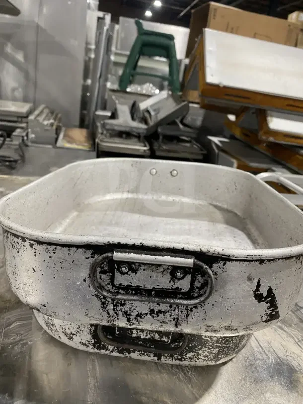 Commercial aluminum roasting/baking pans with handles. Worn condition, stackable design. 2 pans included per bid.