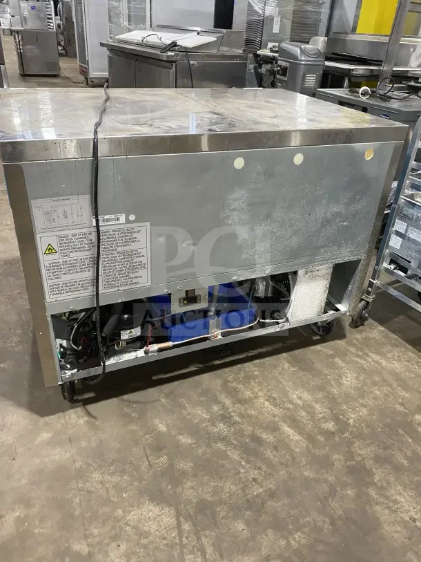 Dukers DUC48F 2-door refrigerated lowboy worktop freezer, stainless steel, poly-coated rack, on casters, model info visible.