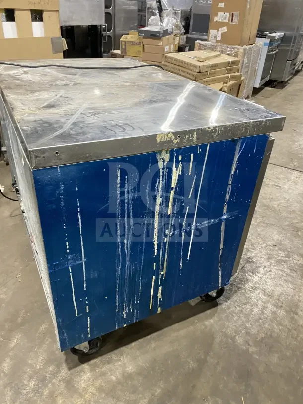 Dukers DUC48F refrigerated lowboy freezer, stainless steel, visible use wear, on casters, with poly-coated rack.